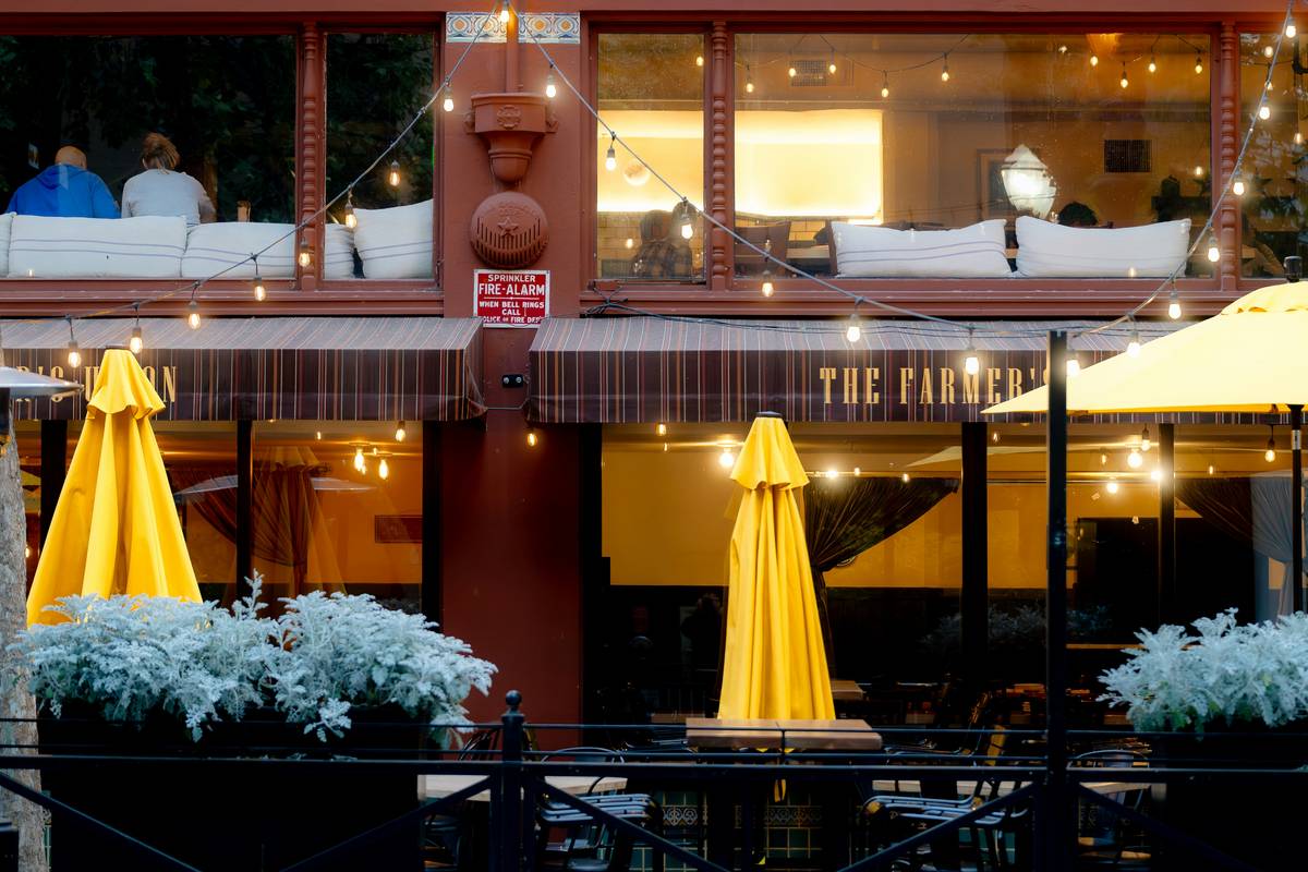large commercial patio umbrellas installed over restaurant seating area with in-ground mount