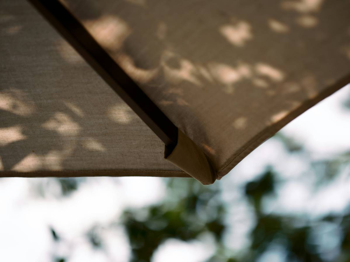 Side-by-side comparison showing decorative item market umbrella patio difference with a flimsy patio model tipping over next to a sturdy market umbrella